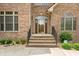 Inviting front entrance with brick steps, decorative door, and manicured landscaping, creating a warm ambiance at 1008 Westcreek Dr, Columbus, IN 47201