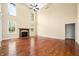 Spacious living room with hardwood floors, tall ceilings, a ceiling fan, and a cozy fireplace at 1008 Westcreek Dr, Columbus, IN 47201