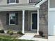 Inviting entryway showcasing brick facade, dark front door, and manicured landscaping at 10144 Camp Creek Way, Indianapolis, IN 46229