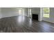 Bright living room featuring luxury vinyl flooring, a cozy fireplace, and abundant natural light from several windows at 10144 Camp Creek Way, Indianapolis, IN 46229