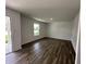 Open living room with luxury vinyl flooring, bright white walls, and a large window offering outdoor views at 10144 Camp Creek Way, Indianapolis, IN 46229