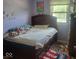 Cozy bedroom featuring a bed with drawers, a window with natural light, and personal decorations for a lived-in feel at 10210 E 33Rd St, Indianapolis, IN 46235