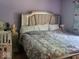 Comfortable bedroom showcasing a well-dressed bed with a plush headboard and decorative side table at 10210 E 33Rd St, Indianapolis, IN 46235