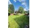 Large, well-maintained backyard with lush lawn, a wooden fence, mature trees, and a deck, ideal for outdoor enjoyment at 10477 Silver Ridge Cir, Fishers, IN 46038