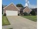 Picture of the exterior showcasing the home's brick facade, well maintained lawn, and two-car garage at 10477 Silver Ridge Cir, Fishers, IN 46038