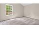 An empty bedroom with plush carpeted floors and a large window at 1139 Fernwood Way, Plainfield, IN 46168
