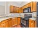Well-equipped kitchen featuring wood cabinets, granite countertops and black appliances at 1139 Fernwood Way, Plainfield, IN 46168