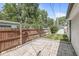 Fenced backyard with stone patio and grassy area featuring a tall wooden fence and a utility shed at 1205 Park Dr, Lebanon, IN 46052