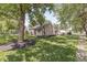 Home featuring a lush lawn, mature trees, and stone exterior, showcasing its curb appeal at 1205 Park Dr, Lebanon, IN 46052