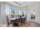 Bright dining room with wood floors, stylish light fixture, and multiple windows offering a scenic view at 12078 Black Mill Pass, Fishers, IN 46040