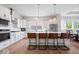 Bright kitchen featuring white cabinetry, stainless steel appliances, and a spacious island with seating at 12078 Black Mill Pass, Fishers, IN 46040