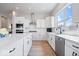 Modern kitchen with stainless steel appliances, white cabinets, a spacious island, and hardwood floors at 12078 Black Mill Pass, Fishers, IN 46040