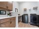 Laundry room with wood cabinets, granite countertops and stainless steel machines at 12078 Black Mill Pass, Fishers, IN 46040