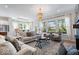 Bright living room featuring hardwood floors, large windows, stylish furniture, and an elegant chandelier at 12078 Black Mill Pass, Fishers, IN 46040