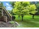 Backyard featuring a staircase leading to a deck and vibrant green lawn at 13020 Lombard Ct, Fishers, IN 46038