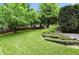 Expansive backyard featuring lush green lawn, mature trees, and tiered landscaping, ideal for outdoor living at 13020 Lombard Ct, Fishers, IN 46038