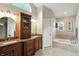 Bright bathroom featuring double vanity with granite countertop, wood cabinets and soaking tub at 13020 Lombard Ct, Fishers, IN 46038