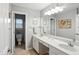 This bathroom features double sinks with white cabinetry and a large mirror over the vanity at 13020 Lombard Ct, Fishers, IN 46038