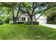 Traditional two-story home with a well-manicured lawn and a two-car garage, nestled amongst mature trees at 13020 Lombard Ct, Fishers, IN 46038