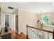 Upstairs hallway featuring hardwood floors, a decorative chandelier, and natural light at 13020 Lombard Ct, Fishers, IN 46038
