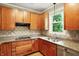 Well-lit kitchen with wood cabinetry, granite counters, stainless steel appliances, and diamond tiled backsplash at 13020 Lombard Ct, Fishers, IN 46038