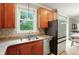 This kitchen has granite countertops, stainless steel appliances, wood cabinetry, and a large window overlooking greenery at 13020 Lombard Ct, Fishers, IN 46038