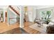 Bright and open living room with hardwood floors, staircase, and large windows, perfect for entertaining and relaxation at 13020 Lombard Ct, Fishers, IN 46038
