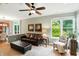 Comfortable living room boasting a leather sofa, large windows with natural light, and hardwood floors at 13020 Lombard Ct, Fishers, IN 46038