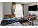 This bedroom features a large window, a television mounted on the wall, and an open-frame desk at 1305 Gumwood Dr, Indianapolis, IN 46234