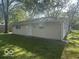 Home featuring neutral vinyl siding, a well-kept lawn, and seamless gutters at 1306 Woodbine Dr, Anderson, IN 46011