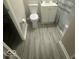 Well-maintained bathroom showcasing modern vanity, toilet, and gray vinyl flooring at 1306 Woodbine Dr, Anderson, IN 46011