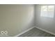 This bedroom features a window with blinds and gray wood-look flooring at 1306 Woodbine Dr, Anderson, IN 46011