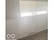 Bedroom with gray wood-look flooring, wainscoting, and natural light from window at 1306 Woodbine Dr, Anderson, IN 46011