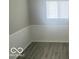 Bedroom with gray wood-look flooring and wainscoting, illuminated by natural light at 1306 Woodbine Dr, Anderson, IN 46011