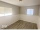 Bedroom with gray wood-look flooring, wainscoting, and natural light at 1306 Woodbine Dr, Anderson, IN 46011