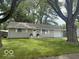 Charming single-story home with lush green lawn, complemented by mature trees at 1306 Woodbine Dr, Anderson, IN 46011