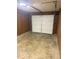 View of the garage door, wood-paneled walls, and concrete floor at 1306 Woodbine Dr, Anderson, IN 46011