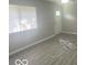 A bright living room with new vinyl flooring, a window, and a front door at 1306 Woodbine Dr, Anderson, IN 46011