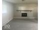 The living room showcases a painted brick fireplace and mantle with neutral carpet at 1306 Woodbine Dr, Anderson, IN 46011