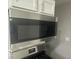 Close-up of modern stainless steel microwave oven with digital display and white cabinets at 1306 Woodbine Dr, Anderson, IN 46011