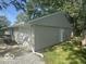 Home featuring neutral vinyl siding, attached garage, and manicured landscaping at 1306 Woodbine Dr, Anderson, IN 46011