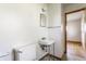 Modest bathroom featuring a wall sink, toilet, medicine cabinet, and doorway to another room at 1310 S Catherwood Ave, Indianapolis, IN 46203