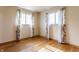 Inviting bedroom with hardwood floors, two windows with floral curtains, and natural light at 1310 S Catherwood Ave, Indianapolis, IN 46203