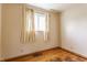 An empty bedroom shows a window with curtains and hardwood floors at 1310 S Catherwood Ave, Indianapolis, IN 46203