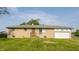 Ranch-style home with light brick, a front lawn, and an attached garage on a sunny day at 1310 S Catherwood Ave, Indianapolis, IN 46203