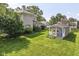 Large, well-manicured backyard with lush green grass and a charming shed featuring a blue door and white trim at 1325 Fordice Rd, Lebanon, IN 46052