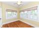 Bright bedroom featuring hardwood floors, white trim, and natural light from windows with floral patterned valances at 1325 Fordice Rd, Lebanon, IN 46052