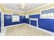 Bedroom features blue paneled walls, patterned carpet, and white ceiling fan at 1325 Fordice Rd, Lebanon, IN 46052