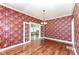 Elegant dining room showcasing hardwood floors, French doors, and decorative wallpaper for a classic touch at 1325 Fordice Rd, Lebanon, IN 46052