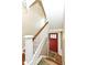 Staircase featuring wood stairs, white banisters, and a red entry door at 1325 Fordice Rd, Lebanon, IN 46052